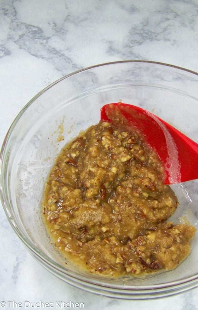 pecan, butter, flour, and sugar mixed together in a glass bowl